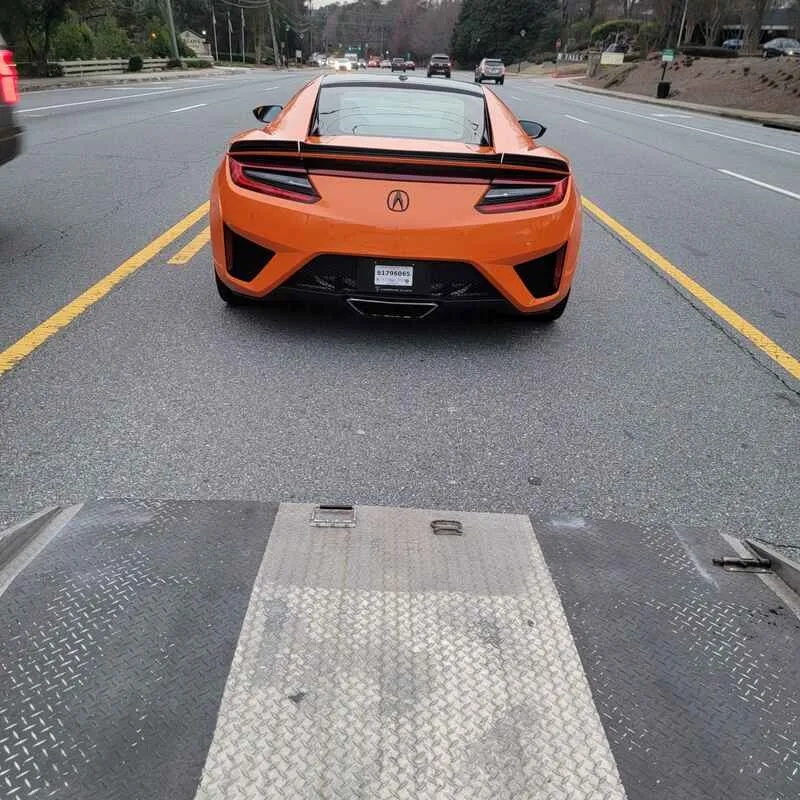 Orange Acura NSX loaded for secure supercar shipping from Atlanta Georgia to Bay Area California — professional enclosed transport