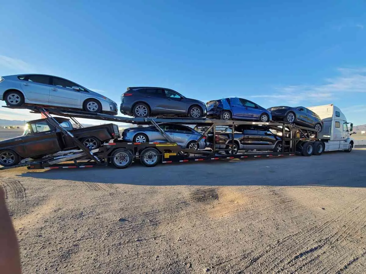 Open auto transport carrier shipping multiple vehicles on an open trailer across the United States